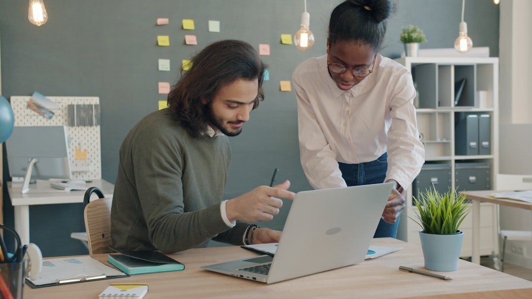 Diverse startup team gathered around a laptop in a bright modern workspace